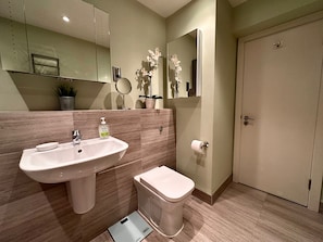 Une salle de bain moderne avec un lavabo, des toilettes et un miroir.