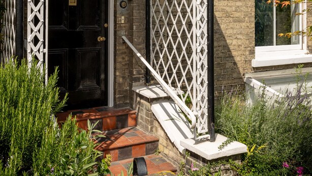 A traditional brick building with a black door, white decorative ironwork, and a small set of steps leading to the entrance. - 3Bd Victorian Townhouse Near Norfolk Broads 4A, 2C (Beccles)