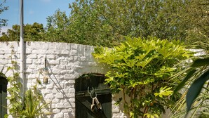A stone wall with a wooden door, a metal pole, and a table with chairs. - 3Bd Victorian Townhouse Near Norfolk Broads 4A, 2C (Beccles)