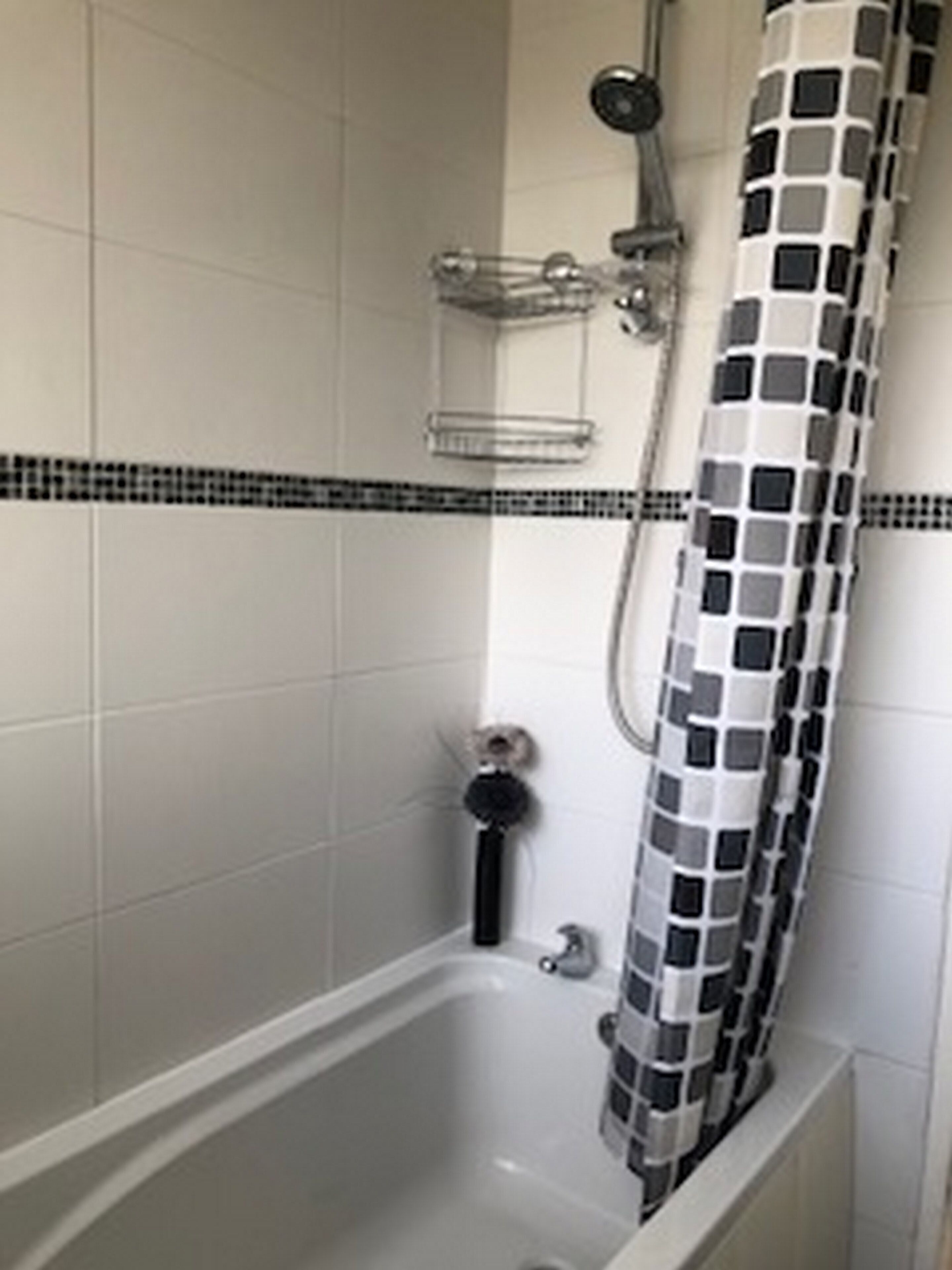 A bathroom with a bathtub, a shower, and a tiled floor.