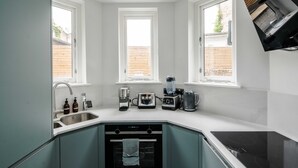 Una cocina moderna con lavavajillas, horno y diversos electrodomésticos.