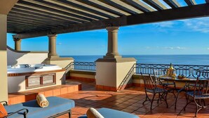 Une terrasse sur le toit avec une piscine, un espace salon et une vue sur l’océan.