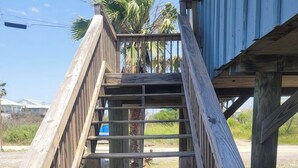 Eine Holztreppe führt zu einem Gebäude mit blauer Fassade.