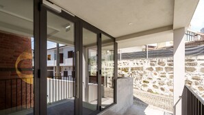Ein modernes Gebäude mit Glastür, Steinwand und Metallgeländer.