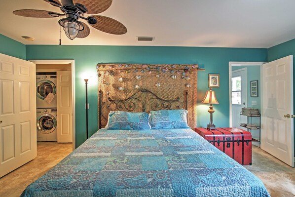 A bedroom with a bed, a ceiling fan, a washing machine in the background, and a suitcase on a table. - Reel in a big fish of the dock, 5 miles to Beach! (Santa Rosa Beach)