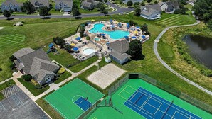 An aerial view of a residential area with a swimming pool, tennis courts, and a basketball court. - Spacious Family-Friendly Condo Near Bethany Beach (Ocean View)