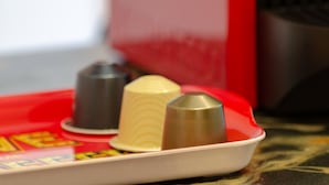 A tray with three condiment containers on a table.