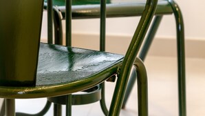 A close-up of a chair with a metallic frame and a green seat. - Setubal Boutique Apartments III by Homing (Setubal)