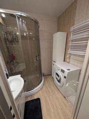 Een douche, handdoeken, zeep, toiletpapier