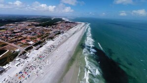 An aerial view of a coastal area with a long sandy beach, a dense urban area with buildings, and a clear blue sky. - MC Style house in Salinas, PA, 8 beds and 4 suites (Salinópolis)