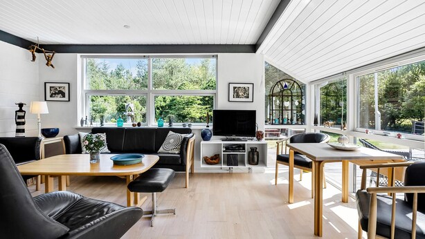 A modern living room with a dining area, large windows, and a TV. - 2 bedroom beautiful home in Jerup (Jerup)