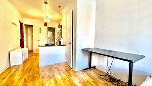Une cuisine compacte avec un îlot central, une petite table à manger et un coin cuisine.