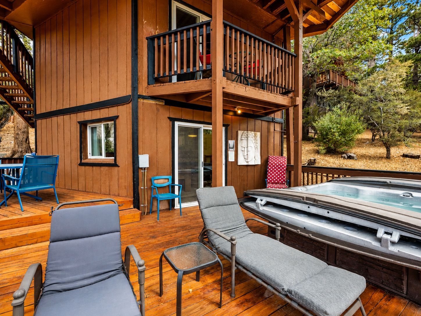 A wooden deck with lounge chairs and a hot tub.