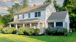 A two-story house with a covered porch, a garage, and well-maintained landscaping.