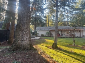 Una casa con jardín delantero, garaje y porche cubierto.
