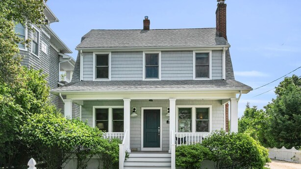 A two-story house with a front porch, a green door, and a mailbox labeled '27'.
