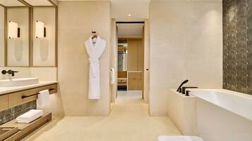 Un baño moderno con un espejo grande, una bañera y un tocador con lavamanos.