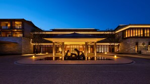 A modern hotel with a spacious entrance, a covered outdoor seating area, and a well-lit facade. - Shu Hua Hotel Tianmu Mountain, Curio Collection By Hilton (Hangzhou)