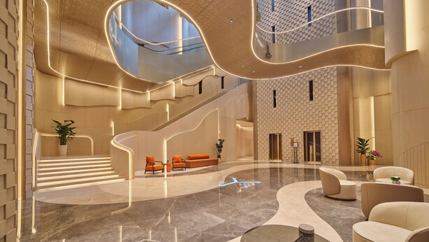 A spacious lobby with a curved staircase, seating areas, and a high ceiling with unique lighting. - The Reserve Hotel Luoyang, Curio Collection By Hilton (Luoyang)