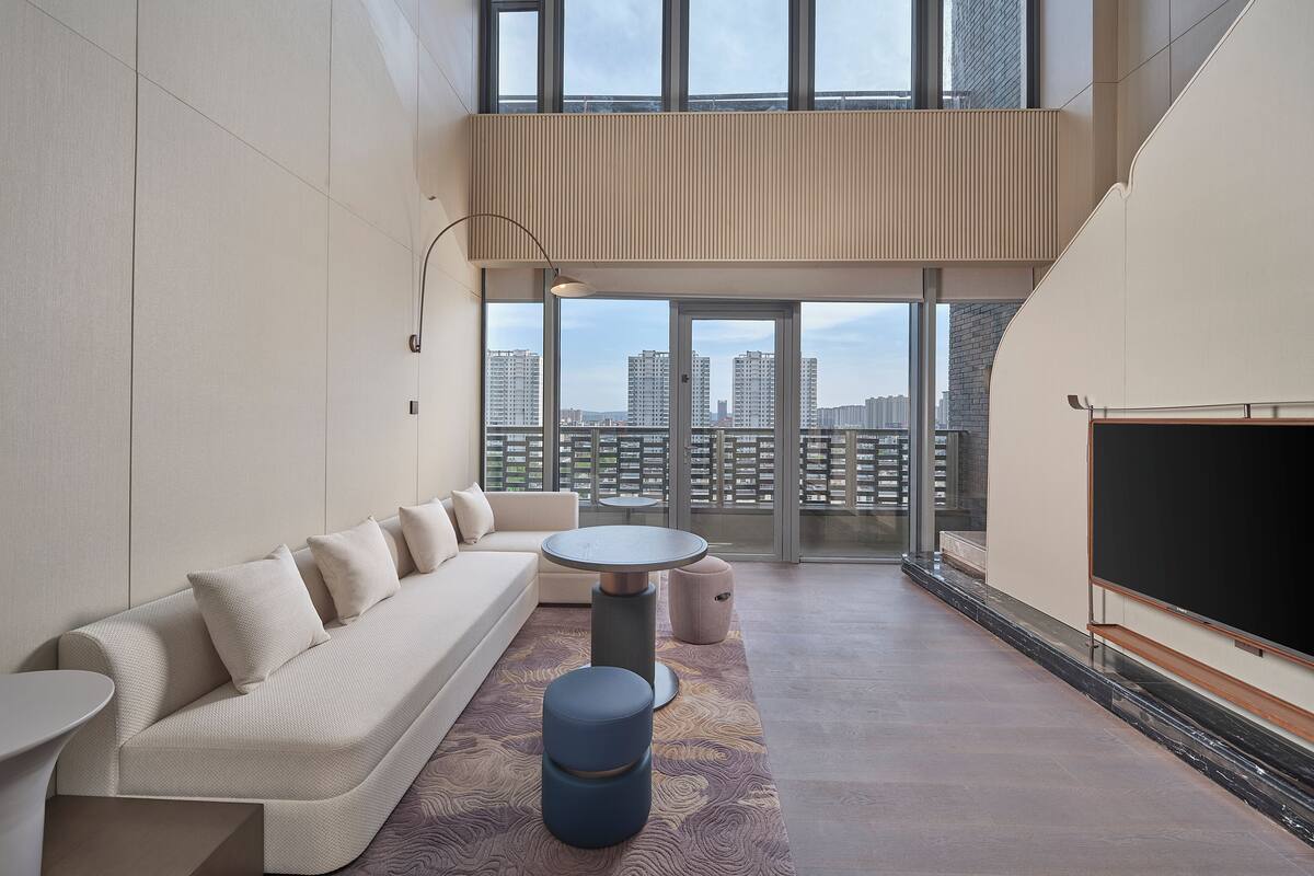 Een moderne woonkamer met een bank, een ronde tafel en een televisie.