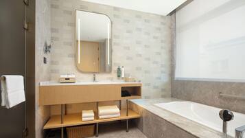 Deluxe Suite, 1 King Bed | Bathroom | Designer toiletries, hair dryer, slippers, towels