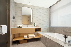 Deluxe Suite, 1 King Bed | Bathroom | Designer toiletries, hair dryer, slippers, towels