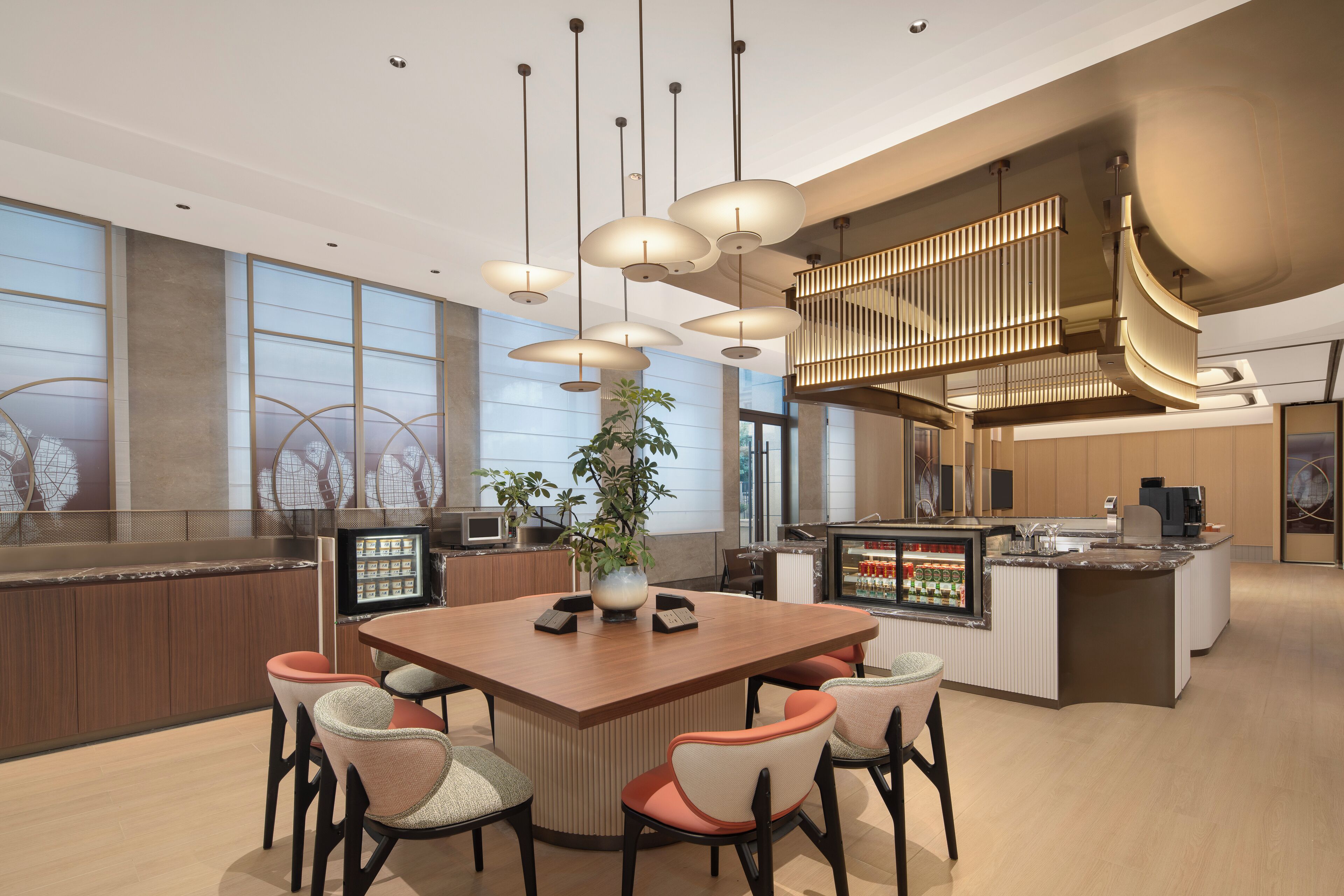 A modern kitchen with a central island, pendant lighting, and a large window.