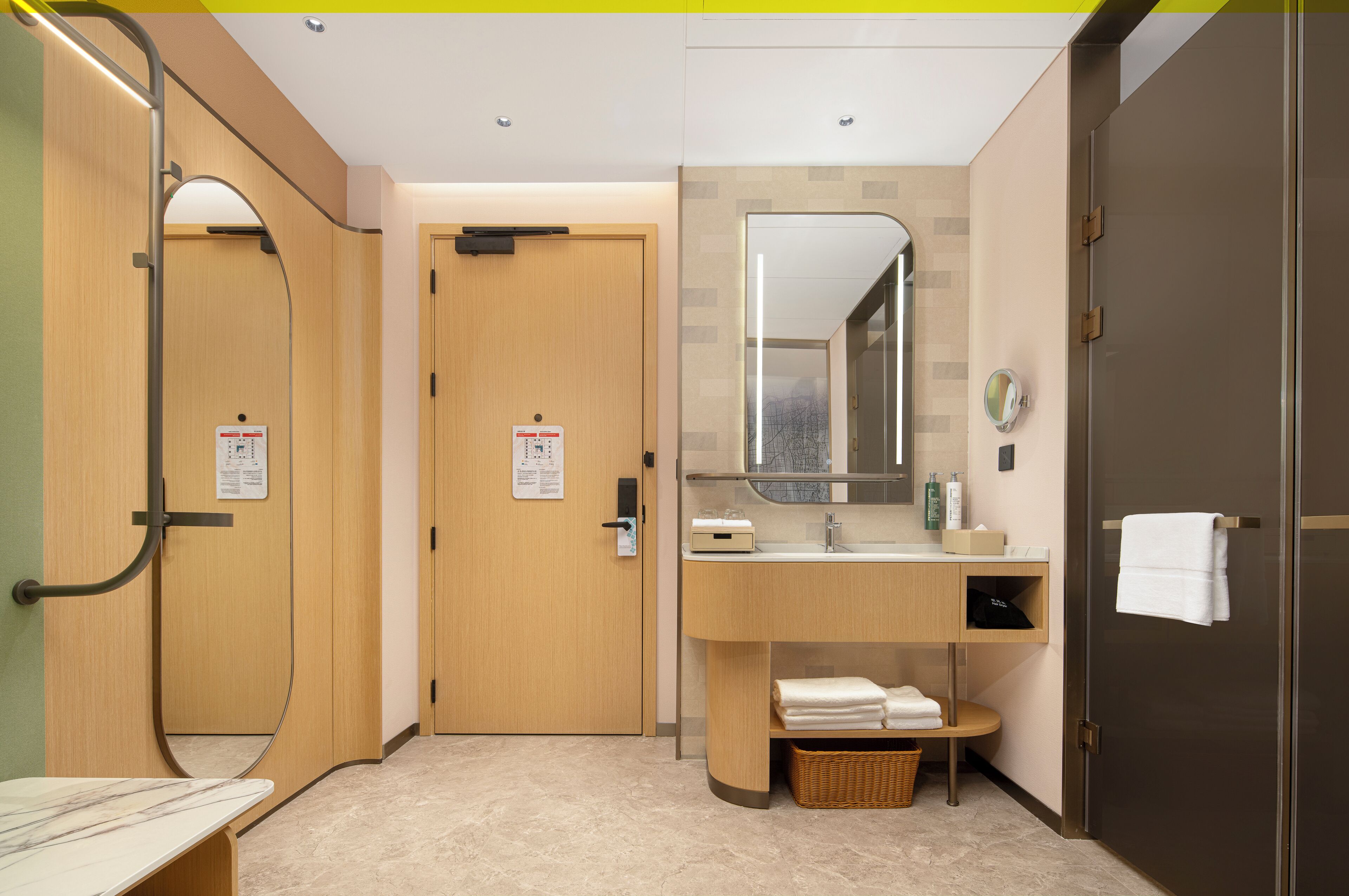 A modern bathroom with a wooden vanity, a mirror, and a towel rack.