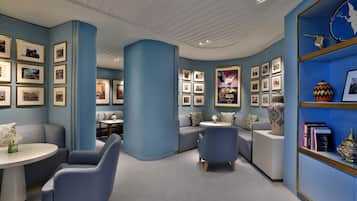 A modern interior with a curved ceiling, blue walls, and a bookshelf with framed pictures.