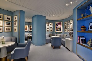 A modern interior with a curved ceiling, blue walls, and a bookshelf with framed pictures. - Waldorf Astoria Rabat Salé (Salé)