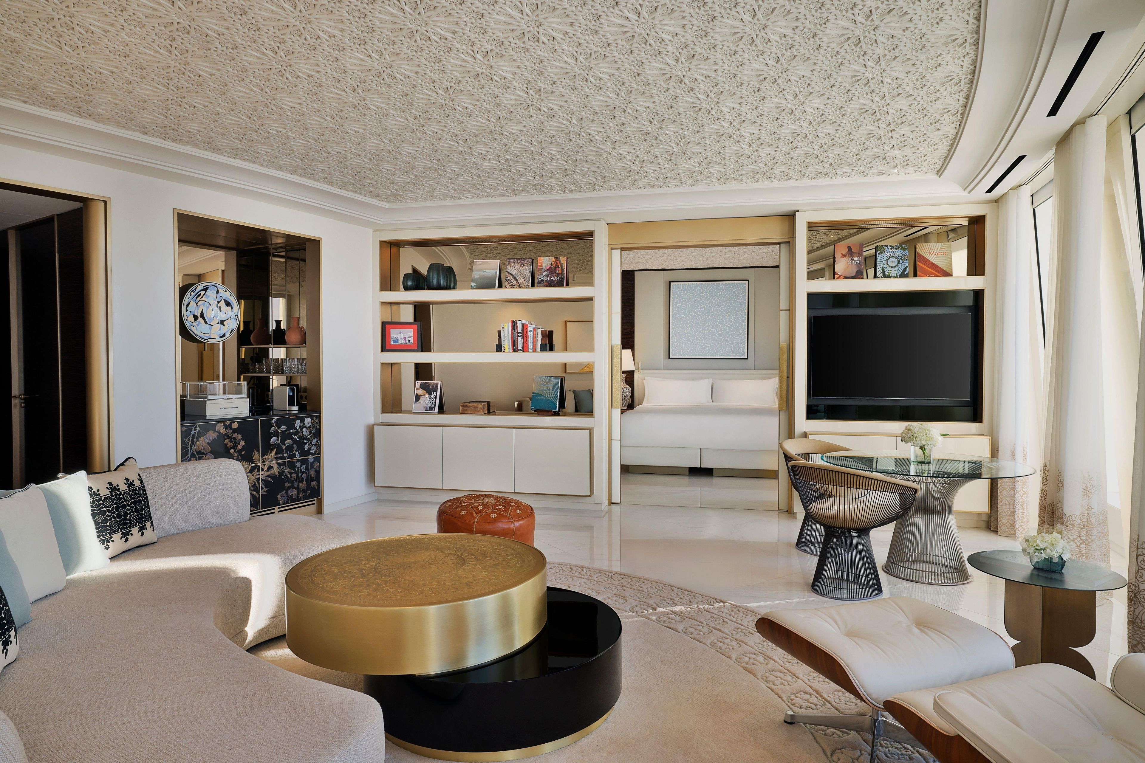 Una sala de estar moderna con un sofá, una mesita redonda y un televisor.