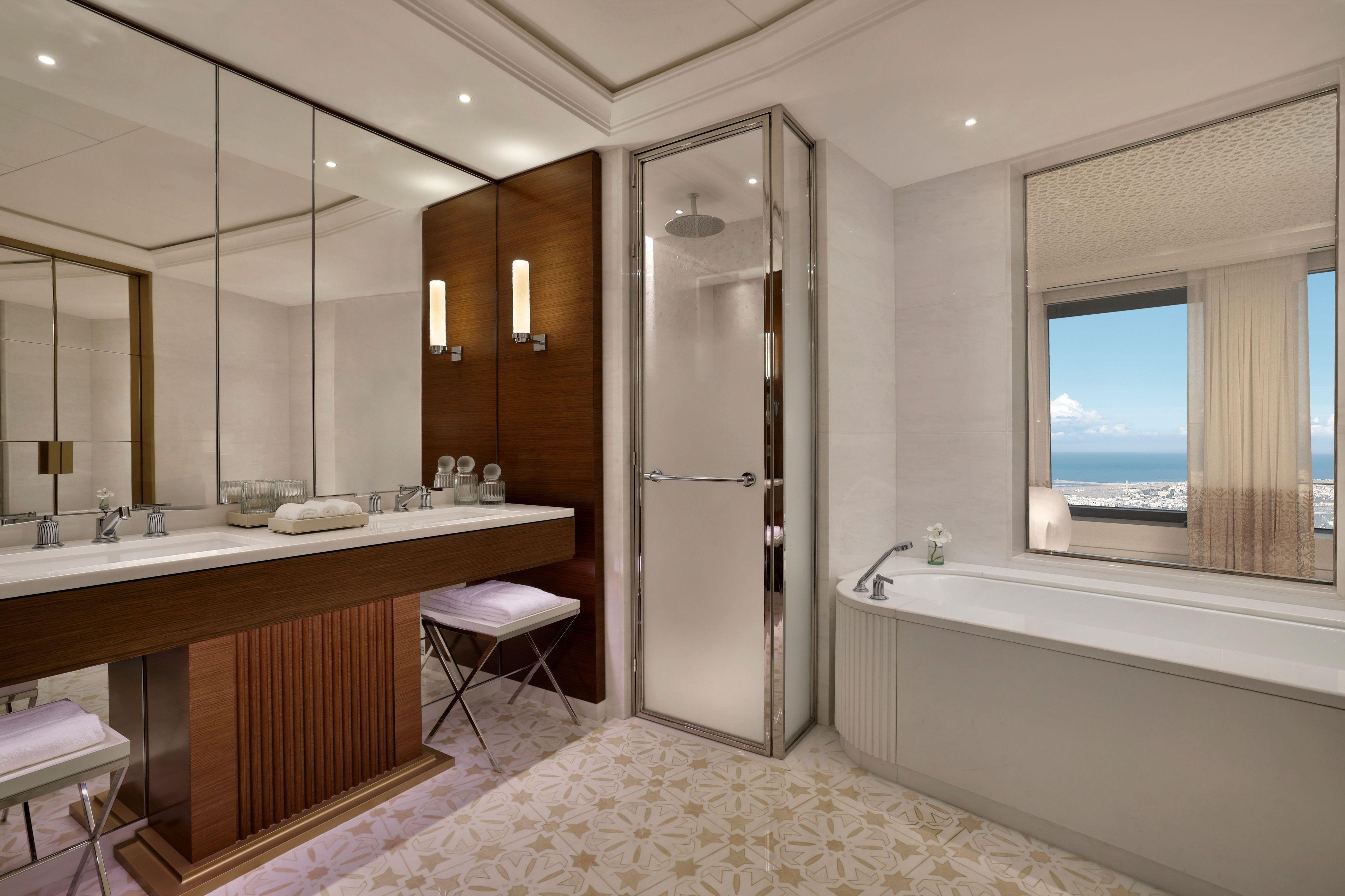 Un baño moderno con un espejo grande, cabina de ducha y bañera.