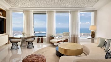 A spacious living room with a panoramic sea view, a round coffee table, and a comfortable seating area.