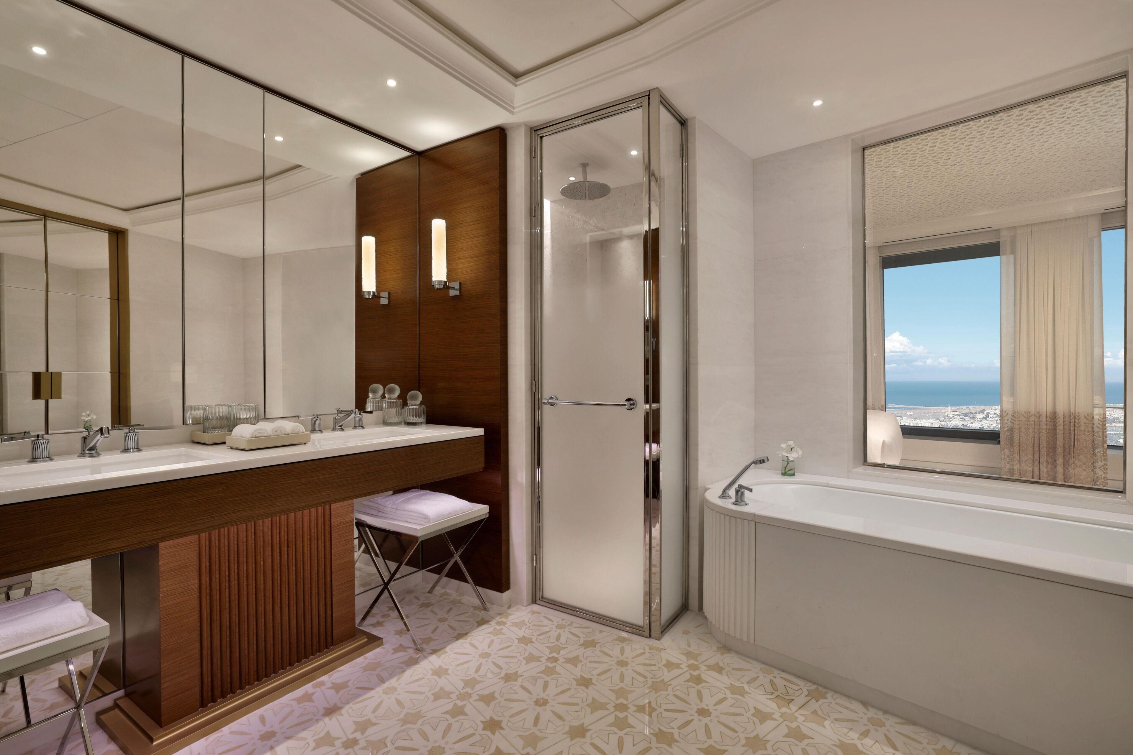 Un baño moderno con un espejo grande, cabina de ducha y bañera.