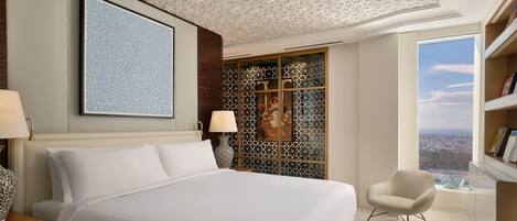 Habitación de hotel con una cama grande, una silla, vistas de la ciudad y un detalle decorativo en la pared.
