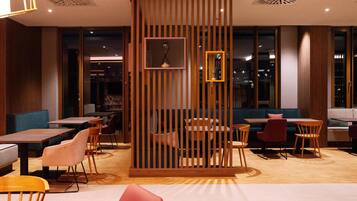 A modern restaurant with wooden partitions, tables, and chairs.