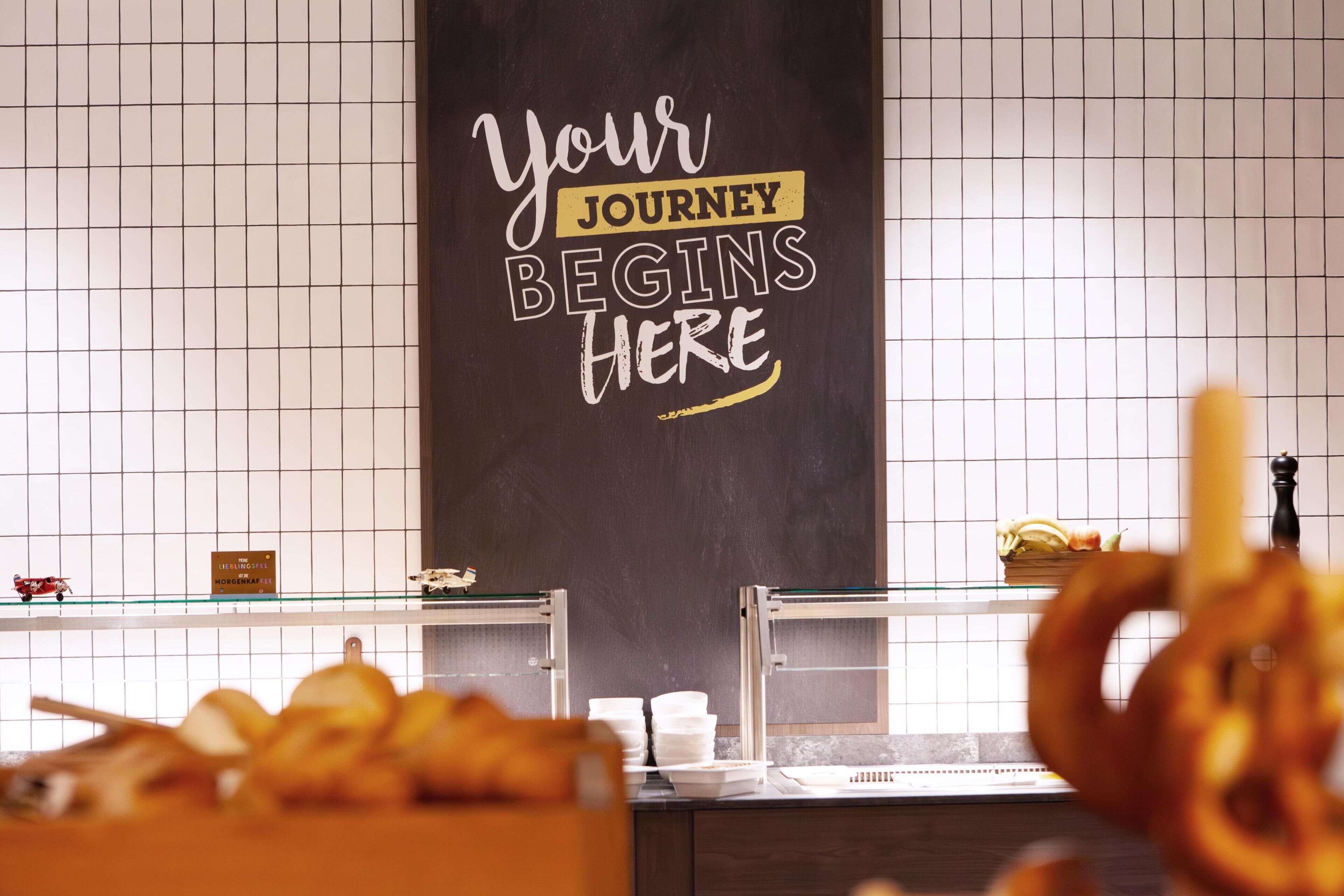 A kitchen area with a chalkboard sign that reads "Your JOURNEY BEGINS HERE".