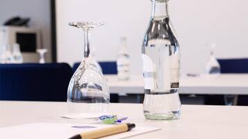 A table with a clear glass bottle and a wine glass.