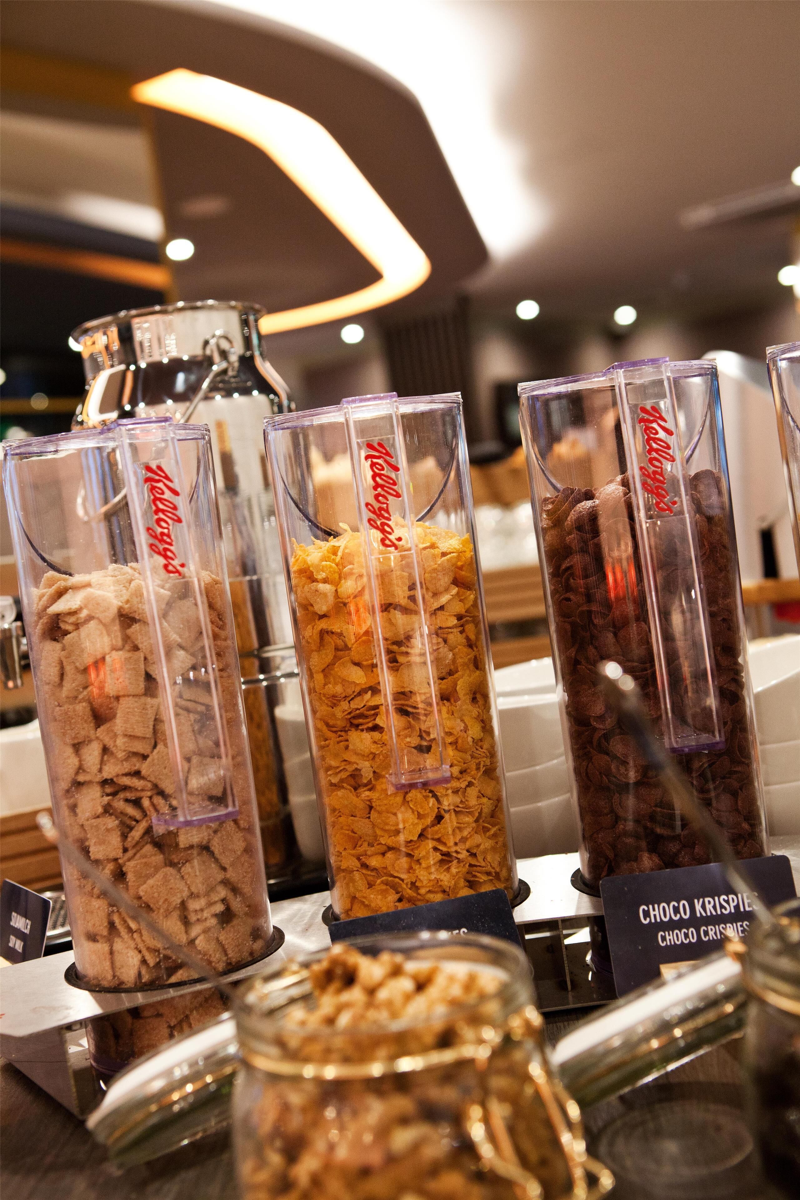 A display of various cereal bars in clear containers with labels.