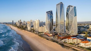 A coastal cityscape with modern skyscrapers, a sandy beach, and a clear view of the ocean. - Luxe Absolute beachfront 2B River and Sunset views/Spa/Sauna/Steam/Free parking! (Surfers Paradise)