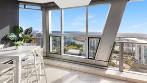 A modern apartment with large windows, a balcony, and a view of the cityscape. - Luxe Absolute beachfront 2B River and Sunset views/Spa/Sauna/Steam/Free parking! (Surfers Paradise)