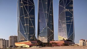 Three modern skyscrapers with a geometric design, situated near a body of water. - Luxe Absolute beachfront 2B River and Sunset views/Spa/Sauna/Steam/Free parking! (Surfers Paradise)