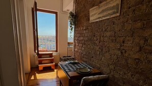 A dining area with a wooden table, chairs, and a view of a cityscape through a large window.