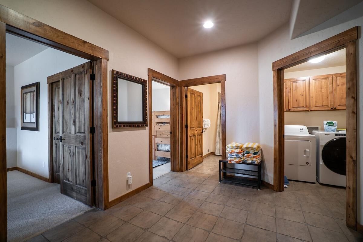A laundry area with a washing machine, a dryer, and a shelf with folded clothes.