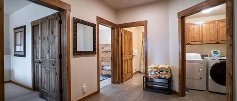 A laundry area with a washing machine, a dryer, and a shelf with folded clothes.