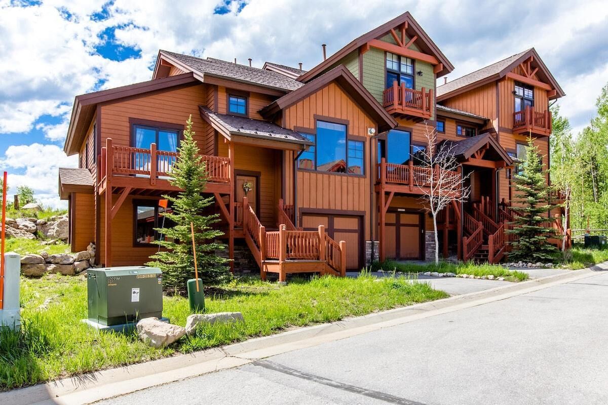 Une grande maison en bois dotée de nombreux balcons et d’une allée.