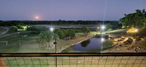 A nighttime view of a zoo enclosure with a pond, trees, and a small bridge. - Apart Club San Pedro, on the Parana River, for nature lovers. (San Pedro)
