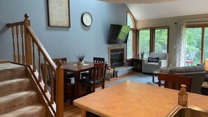 Un espacio habitable amplio con una isla de cocina, una chimenea y un comedor.