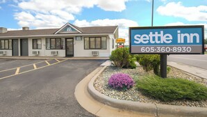 Un motel con un cartel que muestra el nombre 'Settle Inn' y un número de teléfono.