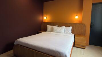 Un dormitorio moderno con una cama grande, dos mesitas de noche y un tocador.
